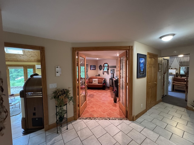 55 Pember Rd, Levant, ME 04456 - hall featuring washer / dryer, baseboards, and light tile patterned flooring