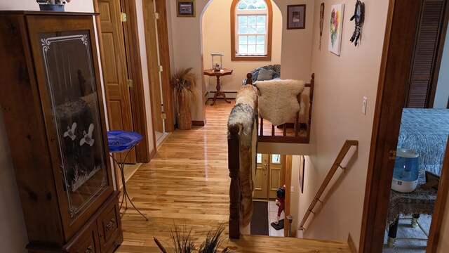 55 Pember Rd, Levant, ME 04456 - hall with light wood finished floors, a baseboard heating unit, arched walkways, and baseboards
