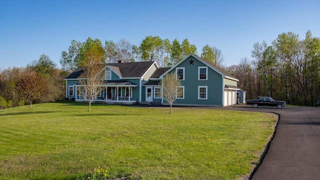 815 Grant Rd, Corinth, ME 04427 - traditional home featuring driveway, a front yard, an attached garage, covered porch, and a chimney