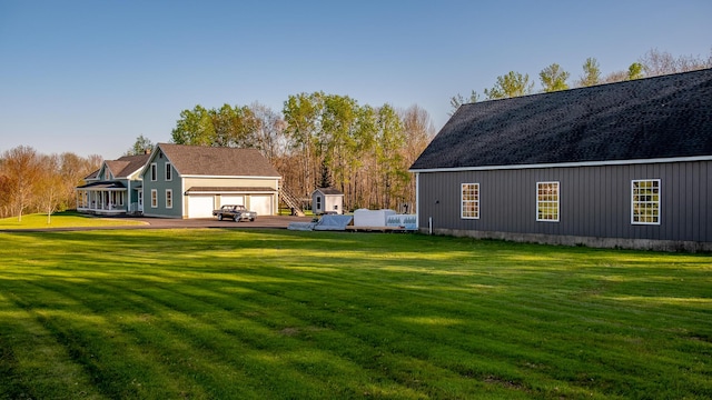 815 Grant Rd, Corinth, ME 04427 - rear view of property featuring a lawn, an outbuilding, and a garage