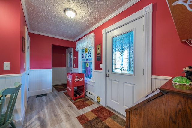 815 Grant Rd, Corinth, ME 04427 - foyer entrance with wood finished floors, a wainscoted wall, an ornate ceiling, a baseboard heating unit, and crown molding