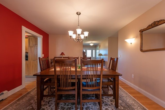 815 Grant Rd, Corinth, ME 04427 - dining room with light wood-type flooring, a chandelier, and baseboard heating