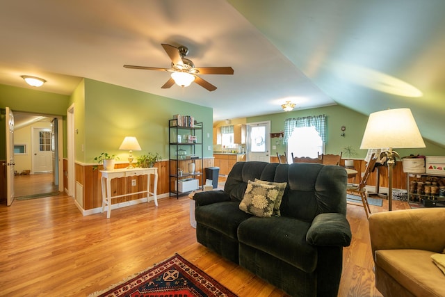 815 Grant Rd, Corinth, ME 04427 - living room featuring light wood-style floors, a ceiling fan, lofted ceiling, and a wainscoted wall