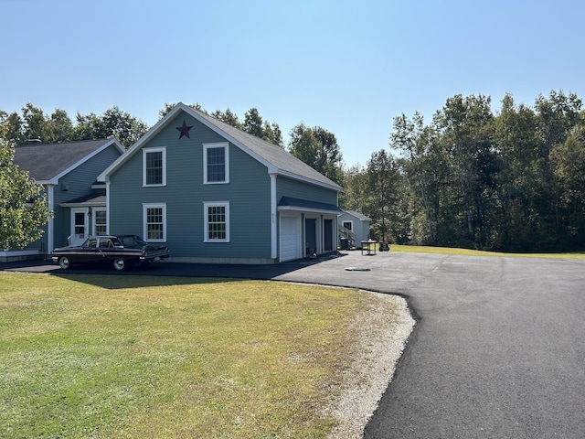 815 Grant Rd, Corinth, ME 04427 - view of front facade featuring a garage, a front yard, and asphalt driveway