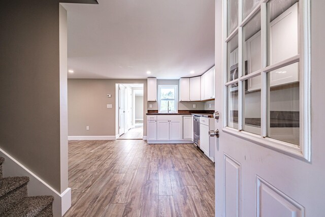 58 Pequawket Trl, Baldwin, ME 04024 - kitchen with dark countertops, light wood-style floors, white cabinets, and recessed lighting
