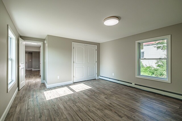 58 Pequawket Trl, Baldwin, ME 04024 - unfurnished bedroom featuring baseboard heating, wood finished floors, and a closet
