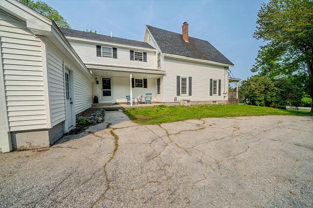 304 Main Rd N, Hampden, ME 04444 - back of property with a chimney, a yard, a porch, and a shingled roof