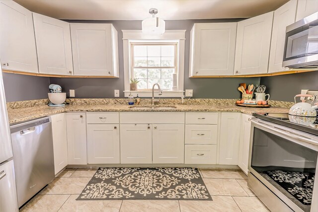 304 Main Rd N, Hampden, ME 04444 - kitchen with stainless steel appliances, a sink, white cabinets, and light stone counters