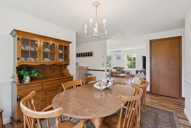 16 Marsh View Ave, Kennebunk, ME 04043 - dining space with an AC wall unit, a chandelier, and wood finished floors