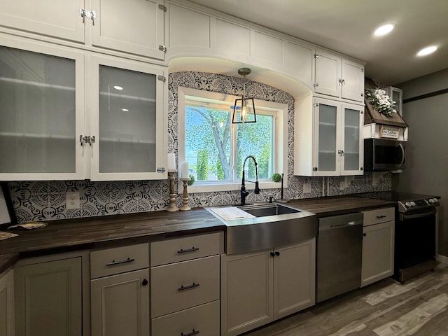 88 Union St, Calais, ME 04619 - kitchen with appliances with stainless steel finishes, wooden counters, backsplash, wood finished floors, and a sink