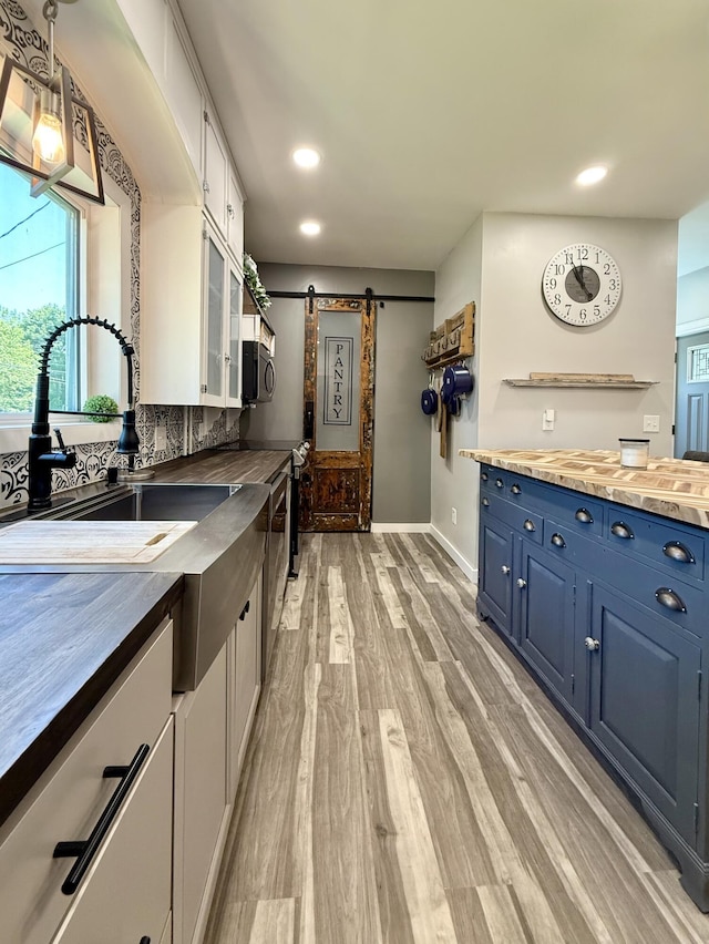 88 Union St, Calais, ME 04619 - kitchen featuring blue cabinetry, a barn door, butcher block counters, recessed lighting, and black microwave