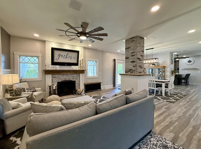 88 Union St, Calais, ME 04619 - living room with decorative columns, a fireplace, wood finished floors, radiator heating unit, and recessed lighting