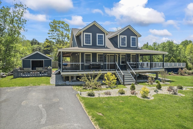 55 Mountain View Ext, Rockland, ME 04841 - farmhouse inspired home with a front yard, an outbuilding, covered porch, and roof with shingles