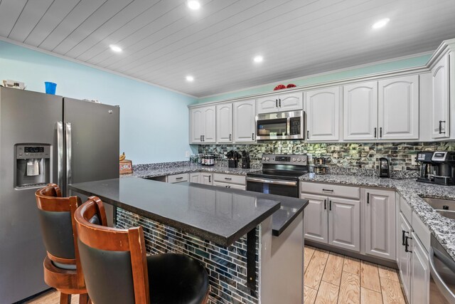 55 Mountain View Ext, Rockland, ME 04841 - kitchen with stainless steel appliances, a kitchen breakfast bar, recessed lighting, tasteful backsplash, and light wood-type flooring