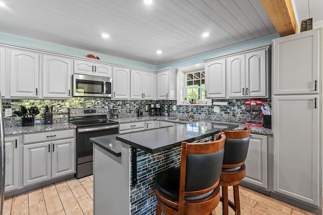 55 Mountain View Ext, Rockland, ME 04841 - kitchen featuring stainless steel appliances, backsplash, a breakfast bar, light wood-type flooring, and a center island