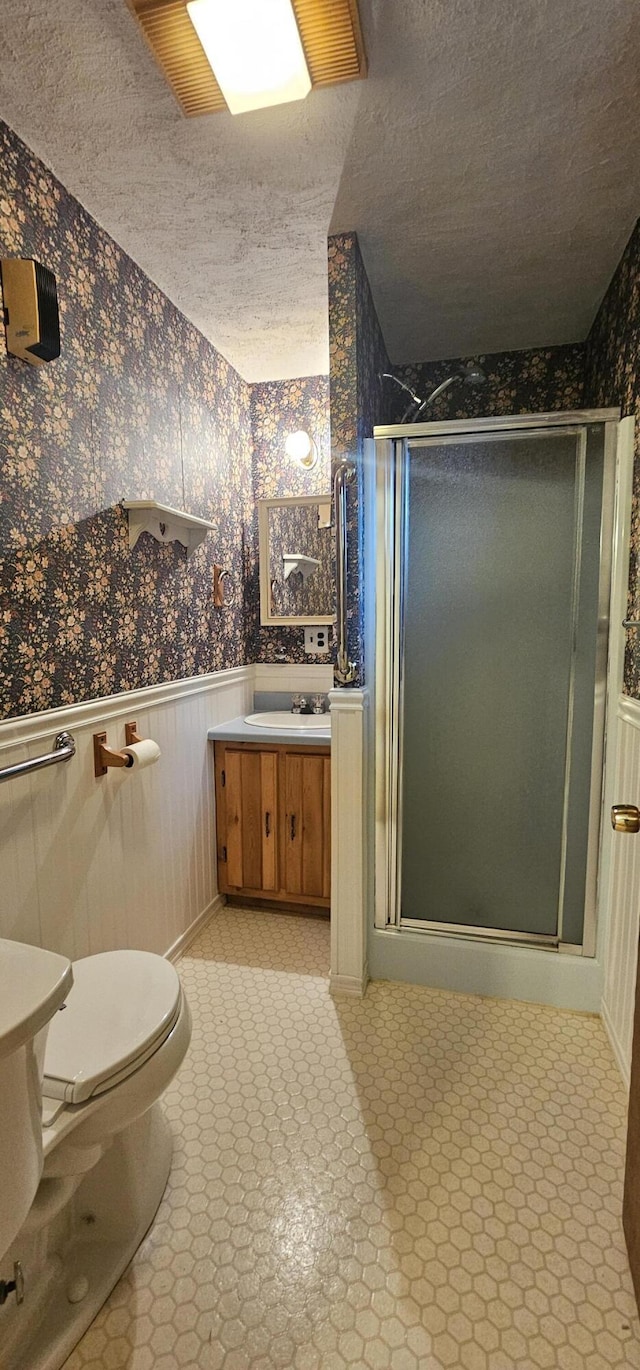 20 Oosoola St, Norridgewock, ME 04957 - bathroom featuring wallpapered walls, a wainscoted wall, vanity, a stall shower, and a textured ceiling