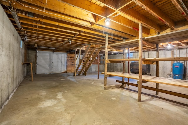 526 Range Rd, Dover-Foxcroft, ME 04426 - unfinished basement featuring oil tank, a water pressure tank, and stairway