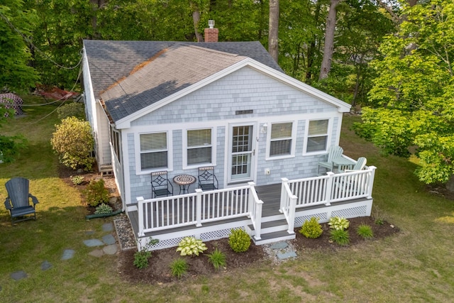 14 Larrys Ldg Unit 14, Ogunquit, ME 03907 - view of front of house with roof with shingles, a chimney, a wooden deck, a front lawn, and view of scattered trees
