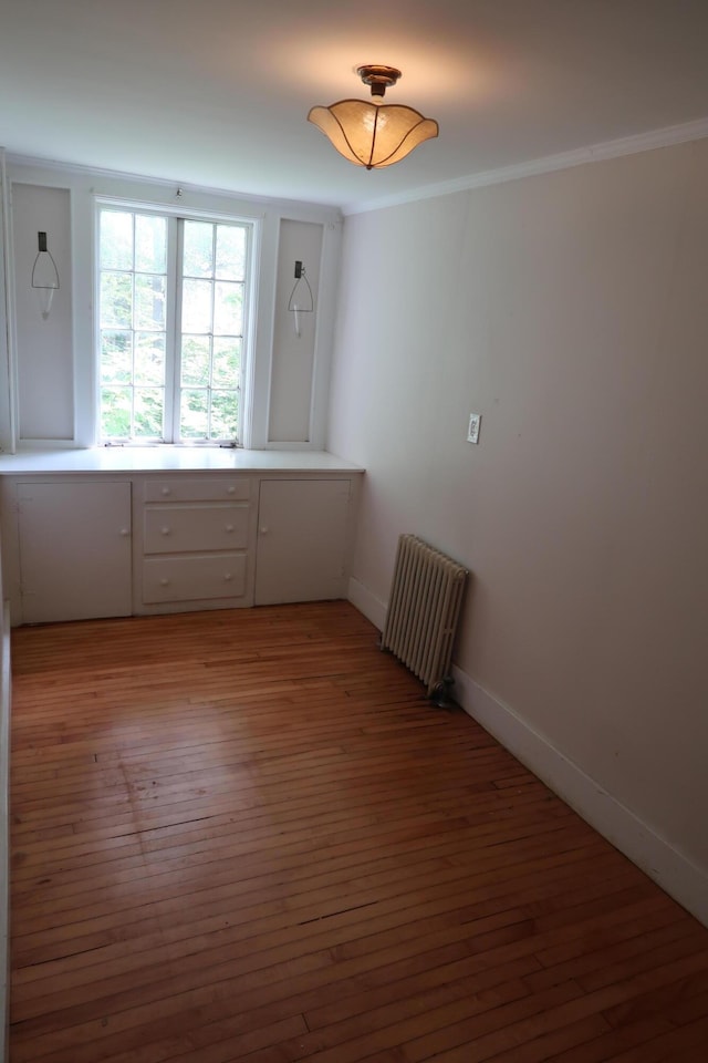7 Elm St, Augusta, ME 04330 - empty room featuring radiator heating unit, light wood-style floors, baseboards, and crown molding