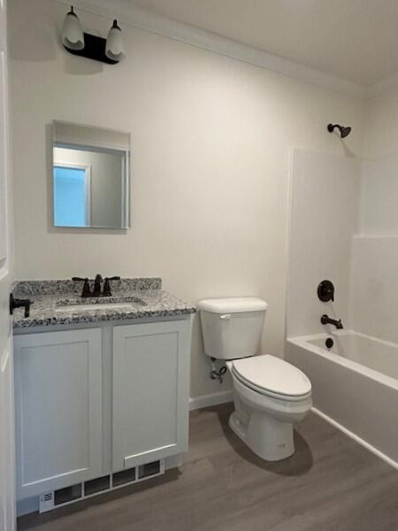 144 Curtis St, Pittsfield, ME 04967 - bathroom featuring toilet, vanity, wood finished floors, crown molding, and tub / shower combination
