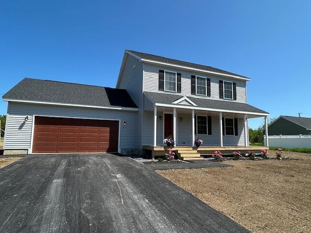 144 Curtis St, Pittsfield, ME 04967 - view of front of property featuring a garage, asphalt driveway, and covered porch