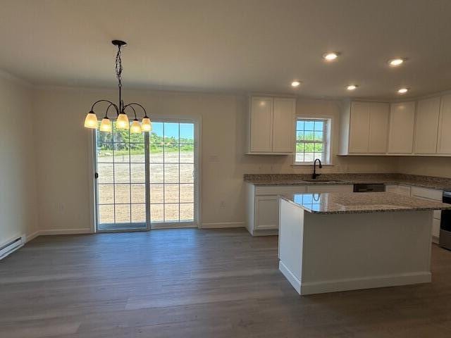 144 Curtis St, Pittsfield, ME 04967 - kitchen featuring wood finished floors, white cabinets, baseboards, a sink, and recessed lighting