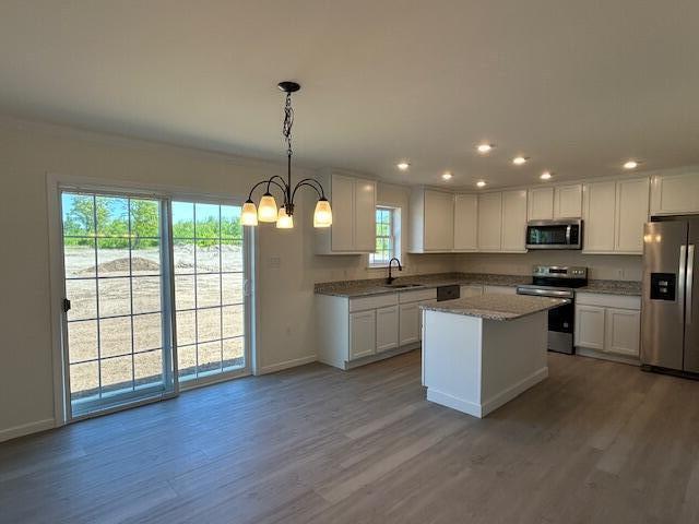 144 Curtis St, Pittsfield, ME 04967 - kitchen with appliances with stainless steel finishes, a sink, baseboards, wood finished floors, and recessed lighting