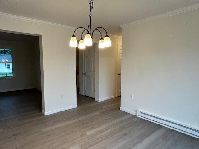 144 Curtis St, Pittsfield, ME 04967 - empty room with baseboard heating, wood finished floors, ornamental molding, baseboards, and a chandelier