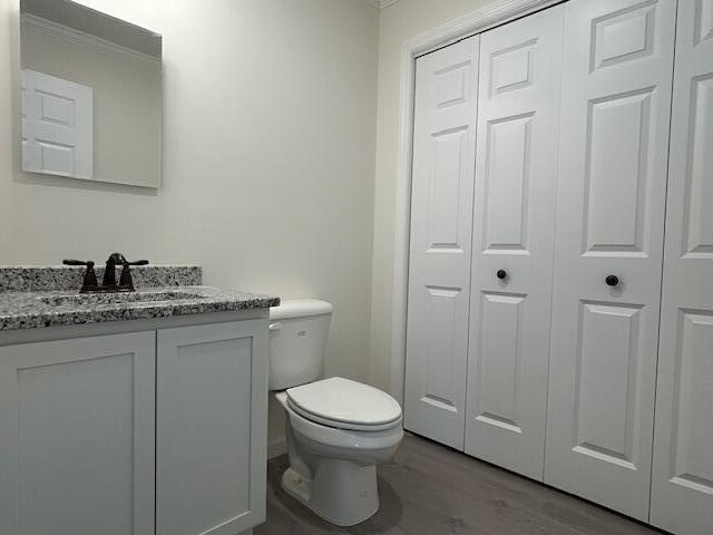 144 Curtis St, Pittsfield, ME 04967 - bathroom featuring a closet, ornamental molding, toilet, vanity, and wood finished floors