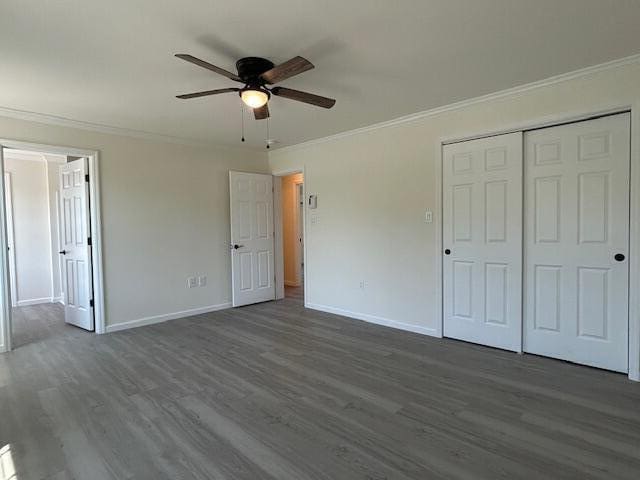 144 Curtis St, Pittsfield, ME 04967 - unfurnished bedroom featuring dark wood finished floors, crown molding, baseboards, a closet, and ceiling fan