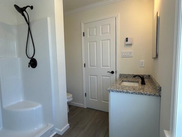 144 Curtis St, Pittsfield, ME 04967 - full bathroom with vanity, wood finished floors, toilet, crown molding, and a shower