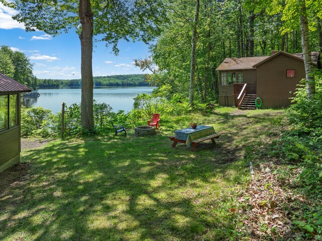 66 Myron Hall Rd, Raymond, ME 04071 - view of green lawn with a fire pit, a deck with water view, and a view of trees