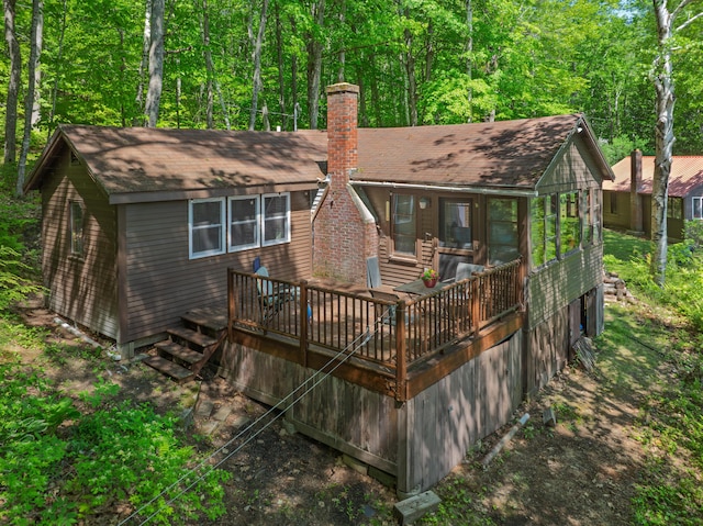 66 Myron Hall Rd, Raymond, ME 04071 - back of house featuring a chimney, a deck, a shingled roof, and a sunroom