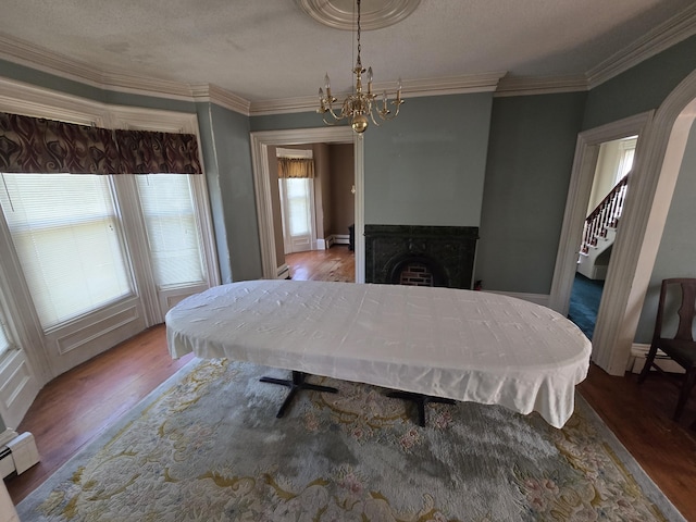 25 Jarvis Gore Dr, Eddington, ME 04428 - bedroom with wood finished floors, a chandelier, multiple windows, a baseboard radiator, and ornamental molding