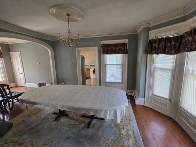 25 Jarvis Gore Dr, Eddington, ME 04428 - dining room featuring arched walkways, light wood finished floors, a textured ceiling, ornamental molding, and baseboards