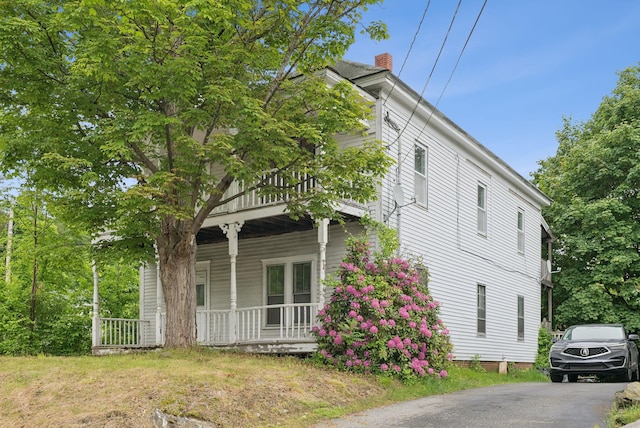 9 Maple St, Jay, ME 04239 - view of home's exterior featuring a porch, a chimney, and asphalt driveway