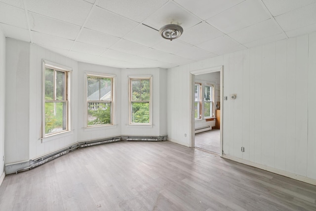 9 Maple St, Jay, ME 04239 - empty room featuring a paneled ceiling, wood finished floors, baseboard heating, and wooden walls