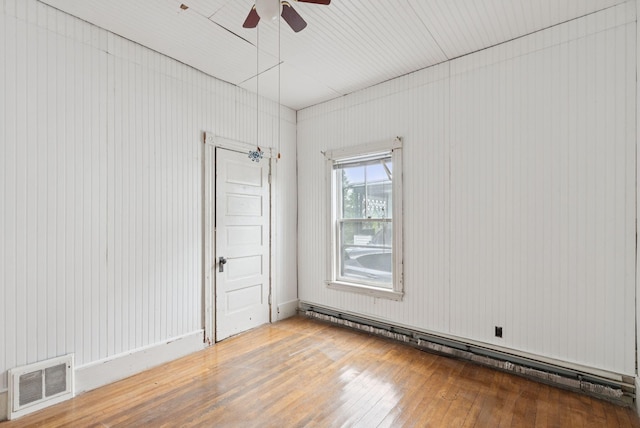 9 Maple St, Jay, ME 04239 - empty room with hardwood / wood-style flooring, a baseboard radiator, and ceiling fan