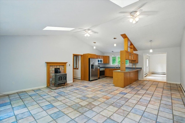 14 Goshen Ln, New Gloucester, ME 04260 - kitchen with appliances with stainless steel finishes, a skylight, a peninsula, a wood stove, and lofted ceiling