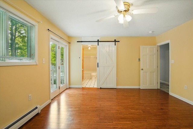 14 Goshen Ln, New Gloucester, ME 04260 - unfurnished bedroom featuring a baseboard heating unit, access to exterior, a barn door, and wood finished floors
