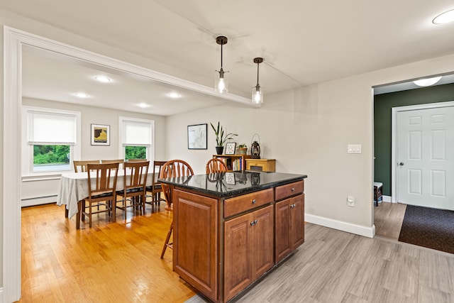 534 Summit St, Portland, ME 04103 - kitchen featuring baseboard heating, light wood finished floors, decorative light fixtures, brown cabinetry, and a kitchen breakfast bar