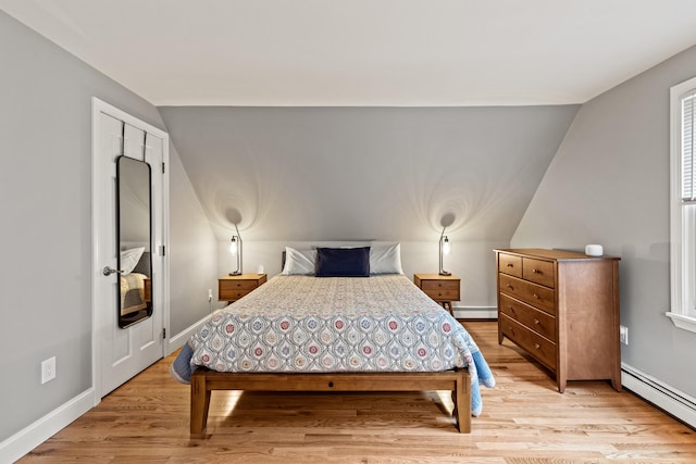 534 Summit St, Portland, ME 04103 - bedroom featuring a baseboard radiator, vaulted ceiling, and light wood-style floors