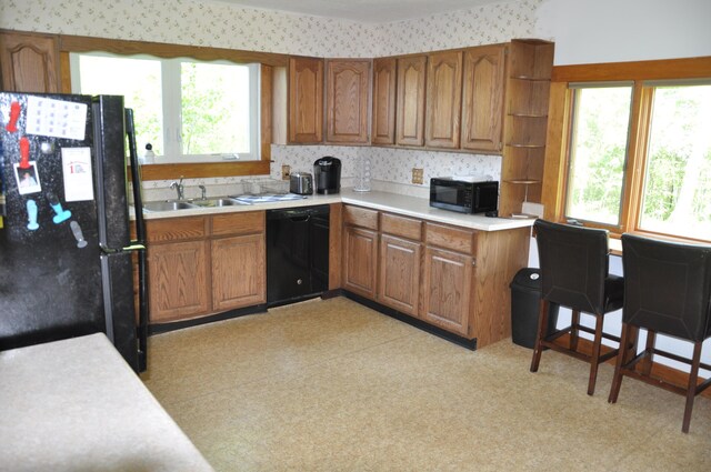 5 Charles St, Orono, ME 04473 - kitchen with black appliances, a sink, brown cabinets, healthy amount of natural light, and wallpapered walls