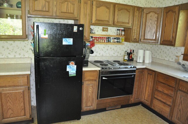 5 Charles St, Orono, ME 04473 - kitchen with freestanding refrigerator, stainless steel range with electric stovetop, wallpapered walls, light countertops, and brown cabinetry