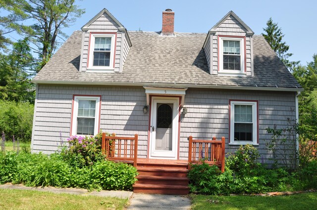 5 Charles St, Orono, ME 04473 - cape cod home featuring a chimney, a shingled roof, and a wooden deck
