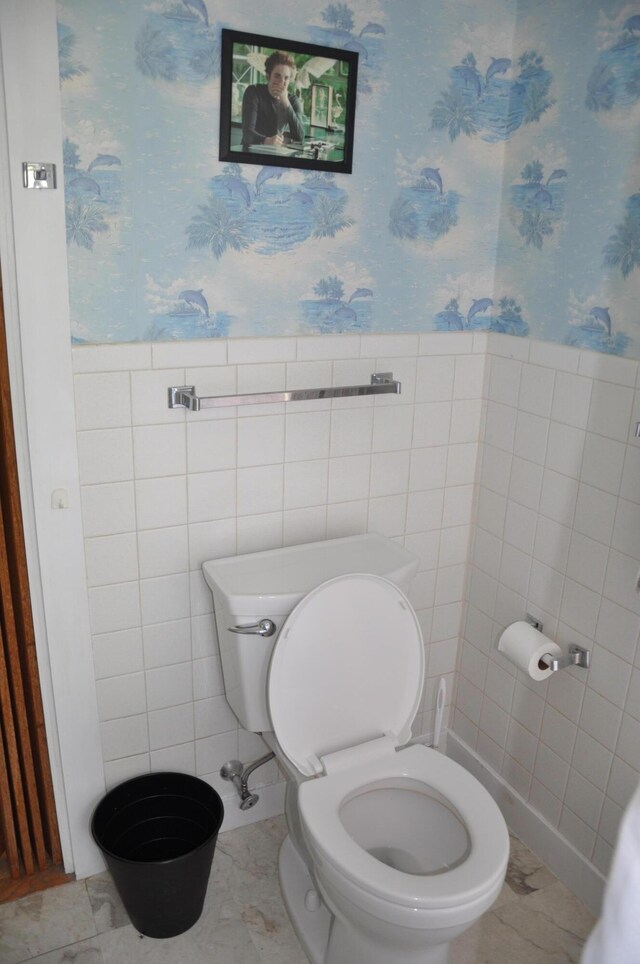 5 Charles St, Orono, ME 04473 - bathroom featuring toilet, wallpapered walls, tile walls, and a wainscoted wall