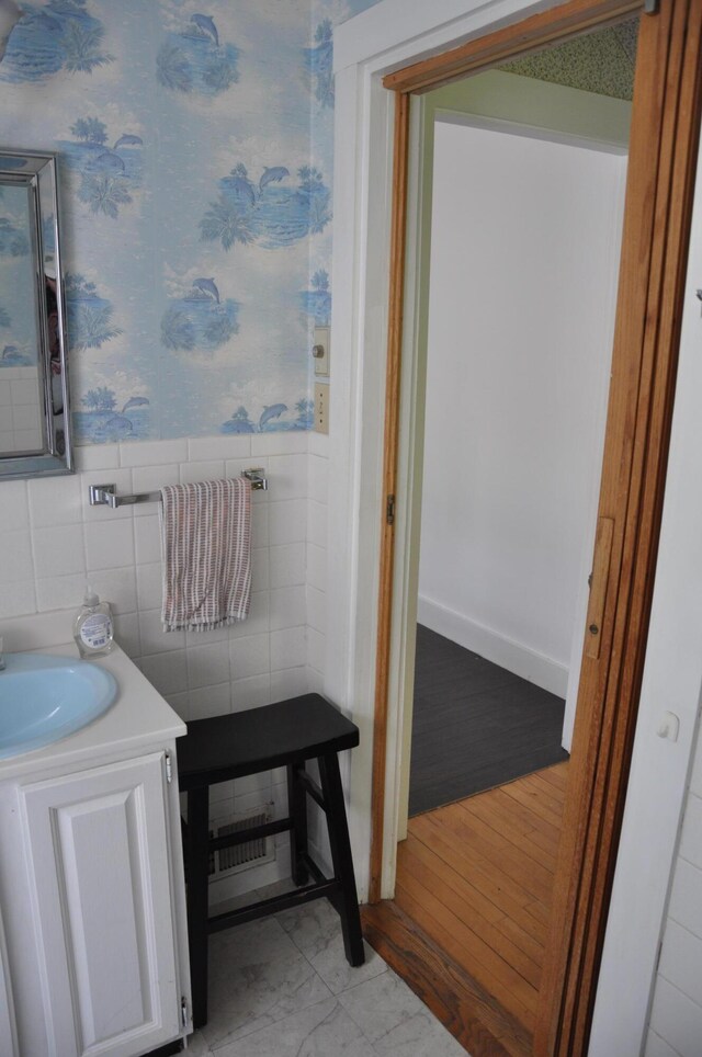 5 Charles St, Orono, ME 04473 - bathroom featuring vanity, wallpapered walls, wainscoting, and tile walls