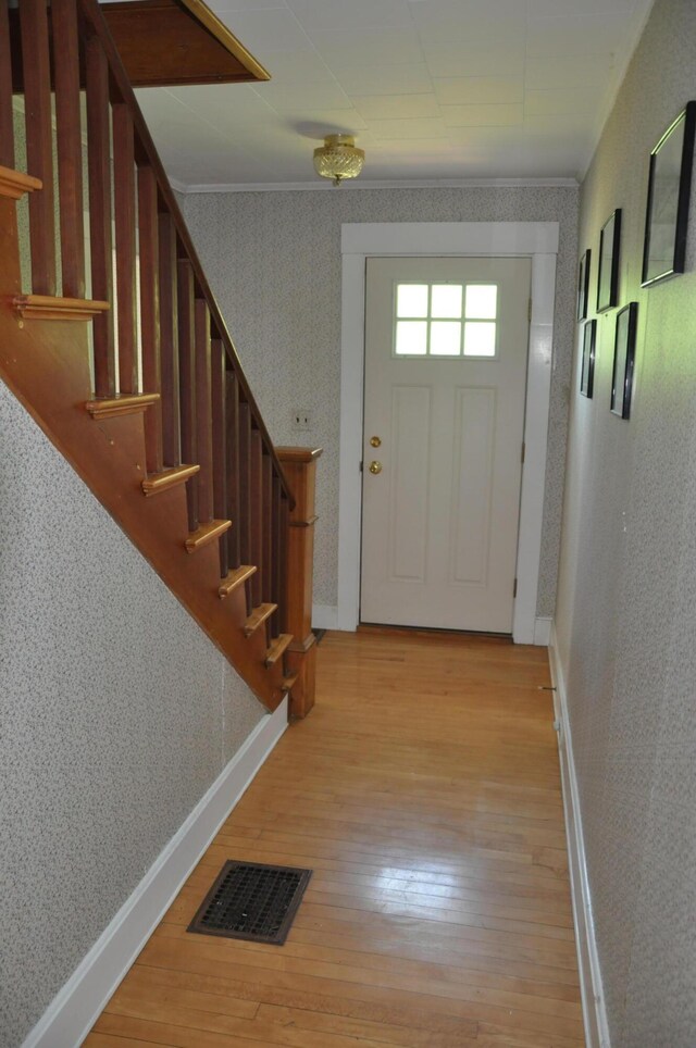 5 Charles St, Orono, ME 04473 - doorway with wallpapered walls, light wood finished floors, stairs, and baseboards