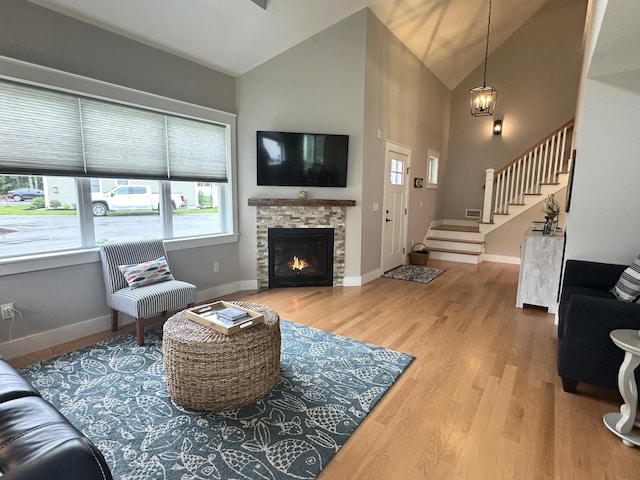 3 Jennifer Ln Unit 1, Wells, ME 04090 - living area featuring stairway, wood finished floors, a stone fireplace, baseboards, and high vaulted ceiling