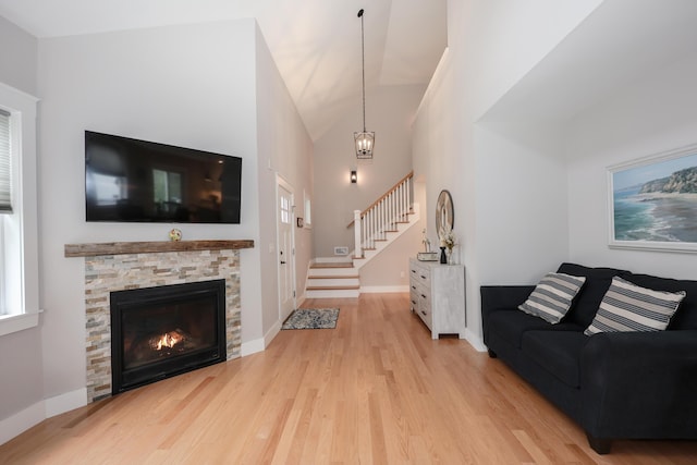 3 Jennifer Ln Unit 1, Wells, ME 04090 - living room with wood finished floors, stairway, a stone fireplace, and lofted ceiling